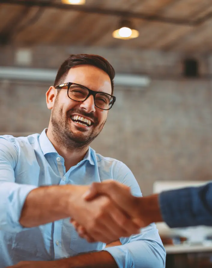 about investment banking Two professionals shaking hands, symbolizing trust and partnership, aligned with the ethos of Calado Capital.